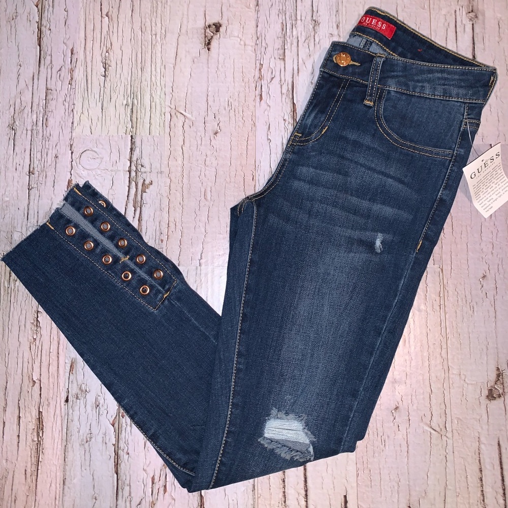 Guess distressed denim with grommet details. Mid rise skinny. Size 25
